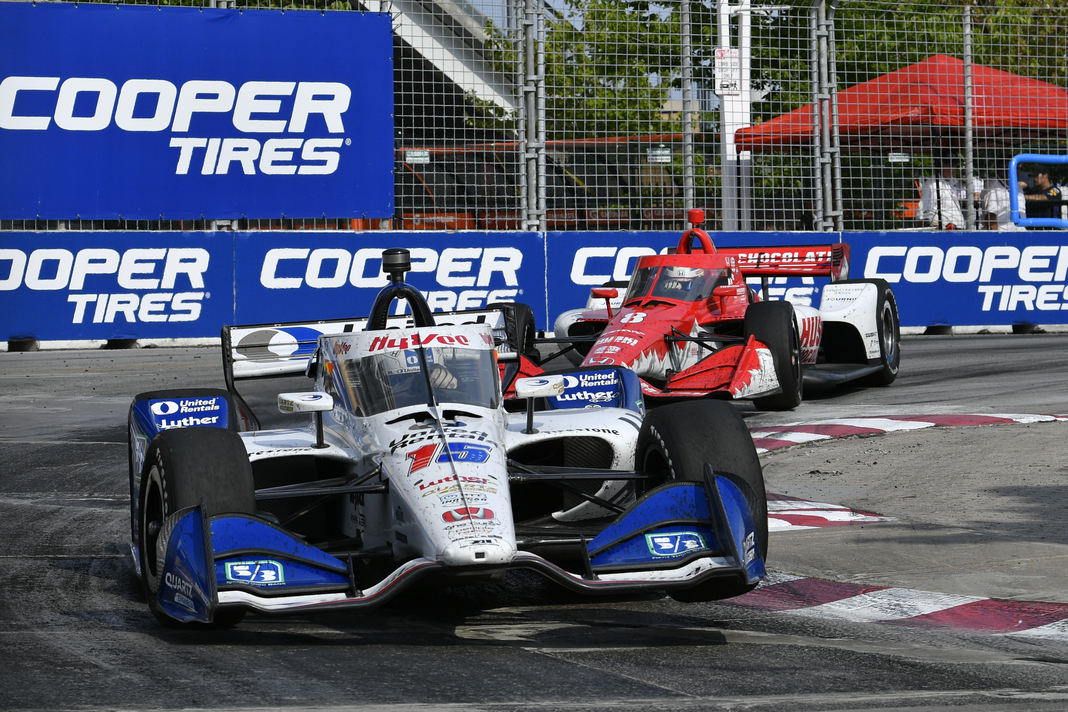 Sebastien Bourdais crossing the finish line with sponsor signage in the background