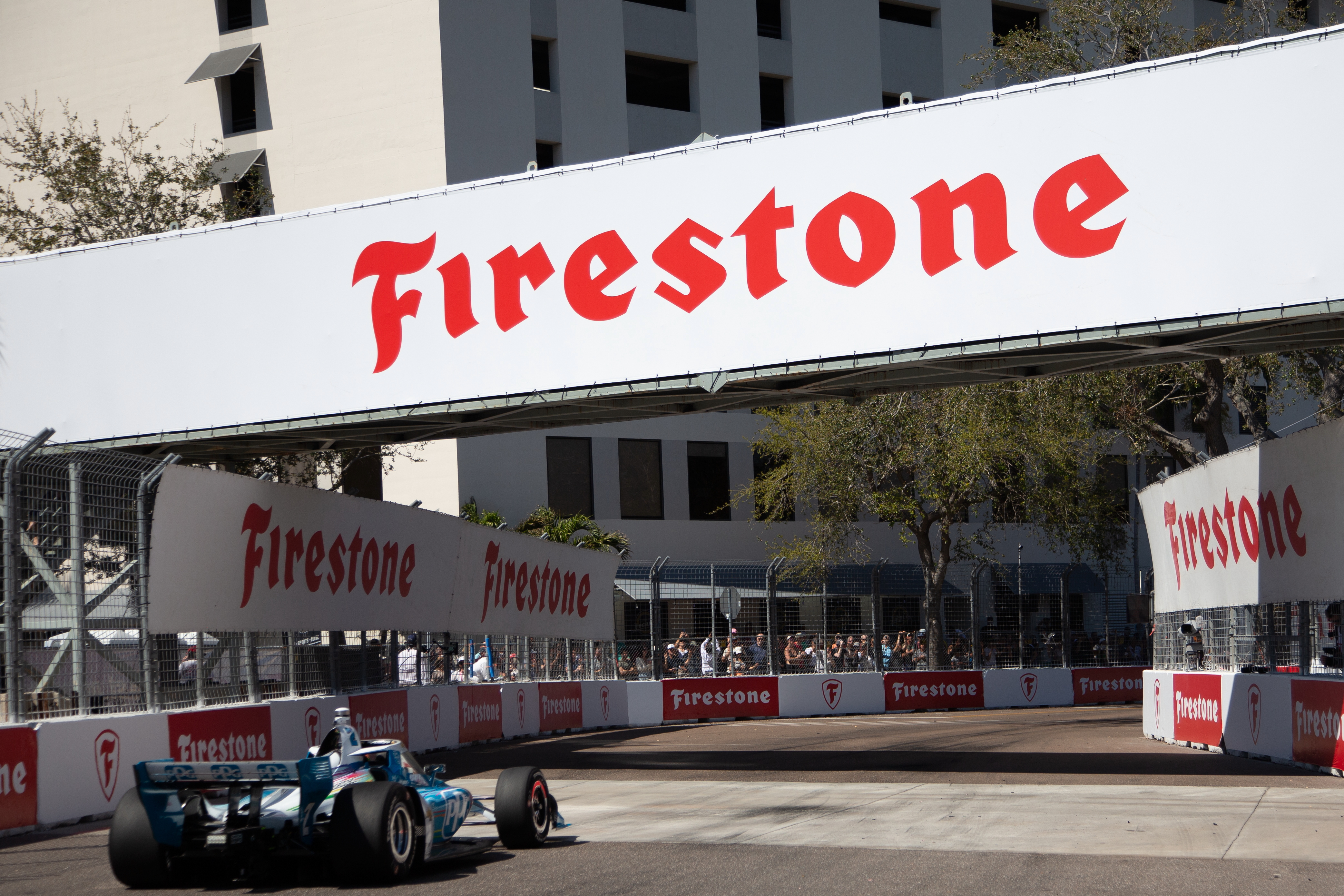 Sebastien Bourdais crossing the finish line with sponsor signage in the background